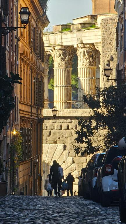 A Roman street opening toward ancient columns among later buildings.
